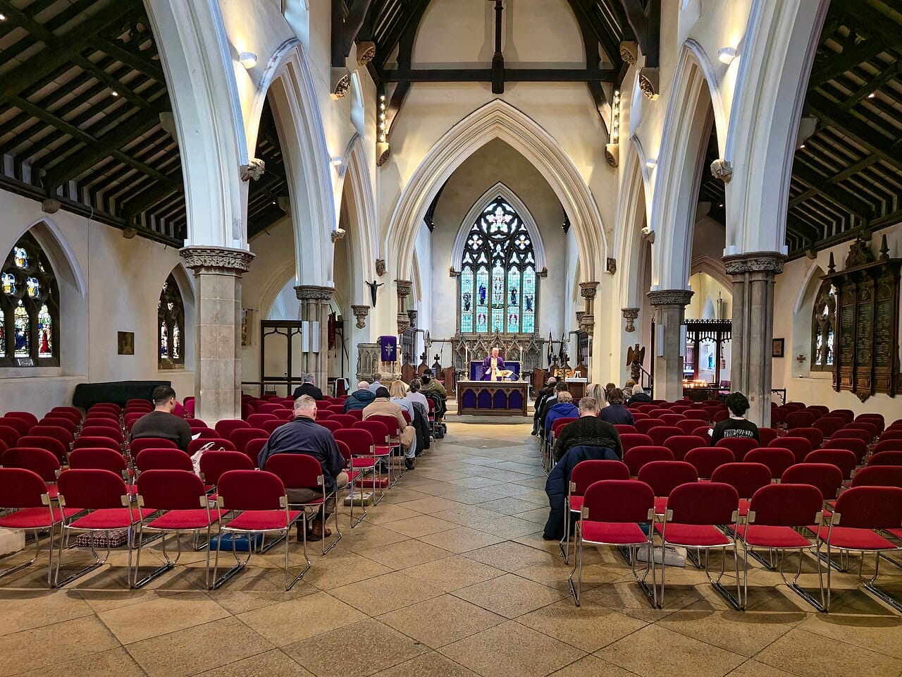 Congregation seated during a church service, viewed down the nave